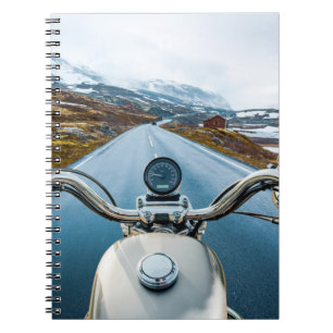 Biker rides a motorcycle on a slippery road throug notebook