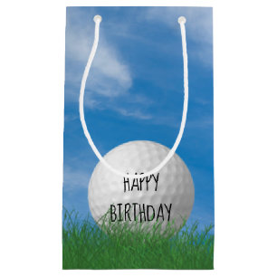birthday golf ball in grass with sky background small gift bag