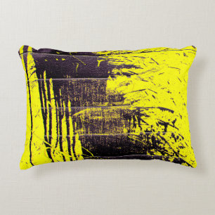 Black abstract splatter paint drips on a bright ye accent pillow