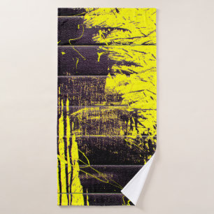 Black abstract splatter paint drips on a bright ye bath towel