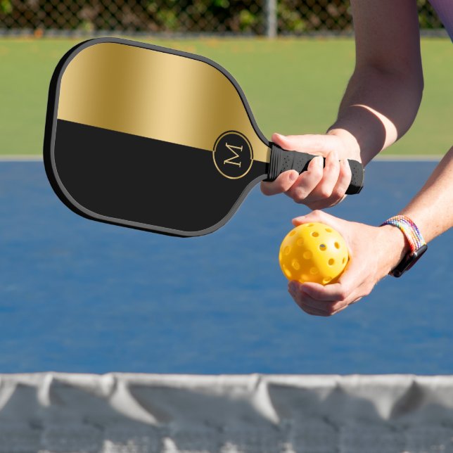 Black and gold split-screen geometric design pickleball paddle (Insitu)