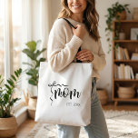 Black and White Bow Script Mom Established Elegant Tote Bag<br><div class="desc">Showcase your maternal pride with this sophisticated tote bag. The design features the word 'Mom' in a graceful black script, complemented by a charming ribbon detail and the year established, 'EST. 20XX'. This clean and classic black and white design is perfect for mothers who appreciate understated elegance. Use it for...</div>