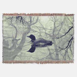 Black and white loon on a lake throw blanket