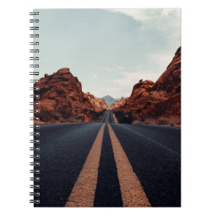 BLACK ASPHALT ROAD BETWEEN BROWN ROCK FORMATION UN NOTEBOOK