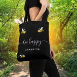 Black bee happy bumble bees summer yellow name tote bag<br><div class="desc">Decorated with happy,  smiling yellow and black  bumblebees. A chic black background. White hand lettered script and the text: Bee Happy.  Personalize and add your name.</div>