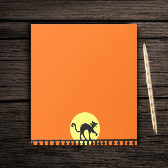 Black Cat Yellow Moon Fence Notepad (Black Halloween cat on black fence with big full yellow moon on orange paper notepad.)
