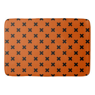 Black cross stitches on orange bath mat