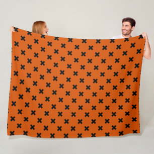 Black cross stitches on orange fleece blanket