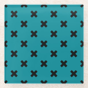 Black cross stitches on teal glass coaster