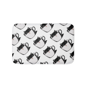 Black kitten with red nose hiding in a cup bath mat