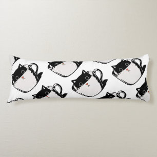 Black kitten with red nose hiding in a cup body pillow