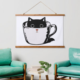 Black kitten with red nose hiding in a cup hanging tapestry
