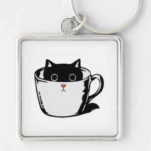 Black kitten with red nose hiding in a cup keychain