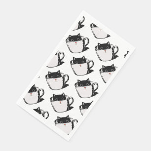 Black kitten with red nose hiding in a cup napkin