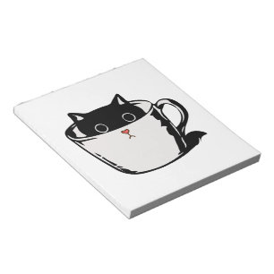Black kitten with red nose hiding in a cup notepad