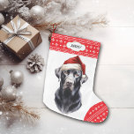 Black Labrador Retriever Santa Hat Large Christmas Stocking<br><div class="desc">The front of this Holiday stocking shows an image of a majestic black Labrador Retriever wearing a Santa hat. The image is placed on a white background, and the toe and top border are a red and white snowflake pattern. On the top border is a white label with your custom...</div>