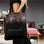 Black rose gold glitter monogram script tote bag<br><div class="desc">A chic black background decorated with rose gold glitter drops. Personalize and add a name. Rose gold coloured text. The name is written with a modern hand lettered style script with swashes. To keep the swashes only delete the sample name, leave the spaces or emoji's in front and after the...</div>