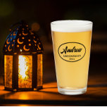 Black Stylized Wedding Groomsman Name Glass<br><div class="desc">Beer glass for the wedding groomsman that features his name printed in black, stylized script inside a black bordered oval along with wedding date. A great party supply idea for a bachelor party! Personalize your beer glass by editing and replacing name and date with your own. Available in many, popular...</div>
