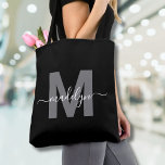 Black Trendy Modern Script Name Monogram Tote Bag<br><div class="desc">Personalized Elegant Black Trendy Modern Script Name Monogram Tote Bag. Add a touch of sophistication to your everyday style with this chic tote bag. Featuring a sleek grey initial centred on a crisp black background, with a clean and modern design on both sides, this tote combines elegance with practicality. Perfect...</div>