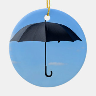 Black umbrella flies in blue sky ceramic ornament