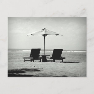 Black & white photo of two deck chairs on a beach postcard