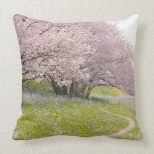 Blossoming Yoshino cherry trees in a field of Throw Pillow