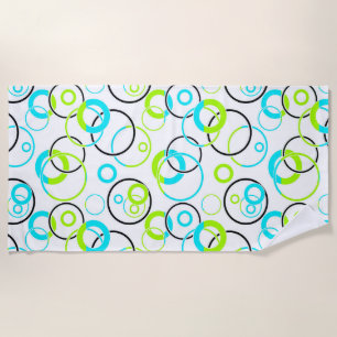 blue green and black rings and circles on white beach towel