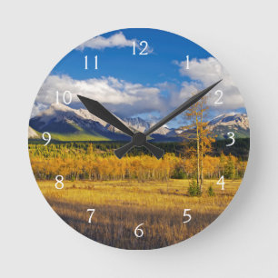 Blue skies and clouds above a meadow round clock