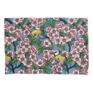 Blue tit birds in the blooming cherry tree on blue pillowcase