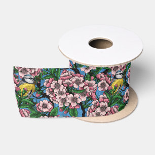 Blue tit birds in the blooming cherry tree on blue satin ribbon