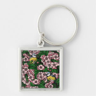 Blue tit birds in the blooming cherry tree on gree keychain