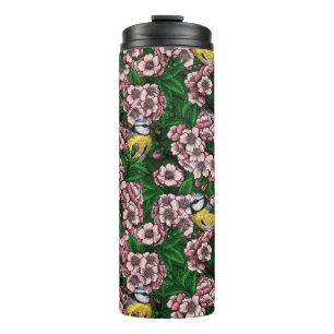 Blue tit birds in the blooming cherry tree on gree thermal tumbler