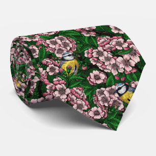 Blue tit birds in the blooming cherry tree on gree tie