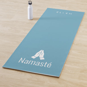 Blue yoga mat with Namasté hands together icon