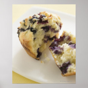 Blueberry muffin split open on a white plate poster