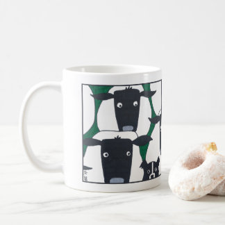 Border collie et tasse de moutons