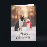 Boston Terrier Christmas Snowman Holiday Card<br><div class="desc">A charming winter holiday scene featuring a Boston Terrier sitting in fresh snow beside a cheerful little snowman wrapped in a bright red scarf. Soft golden winter light and gently falling snow create a peaceful seasonal moment that highlights the expressive face and playful personality Boston Terriers are known for. Perfect...</div>