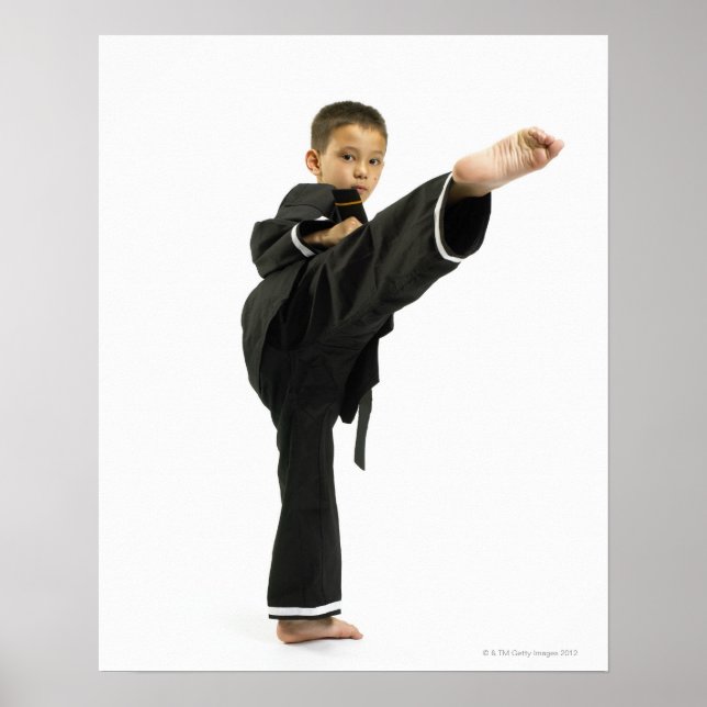 Boy (6-8) in karate outfit kicking poster (Front)