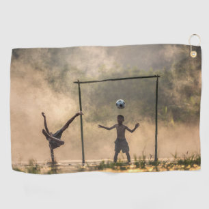 Boy kicking a football in the water Towels