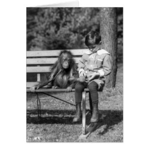 Boy seated with orangutan at the National Zoo