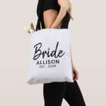 Bride Script White Black Established Date Monogram Tote Bag<br><div class="desc">You can not go without this Bride Script White Black Established Date Monogram Tote Bag. It is designed on both sides with "bride" in modern black script lettering. Personalized with bride's name and established year of wedding. Great gift idea for bridal shower, bachelorette party and honeymoon. CLICK PERSONALIZE TEMPLATE OPTION...</div>