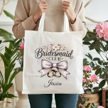 Bridesmaid Club Coquette Floral Bow Wedding Party Tote Bag<br><div class="desc">Gift your bridal party something truly special with this Bridesmaid Club tote bag! Featuring a romantic coquette-style cream bow, delicate pink flowers, and elegant gold rings, this bag is a must-have for any modern wedding. Use it as a wedding welcome bag, a bridesmaid proposal gift, or for carrying essentials on...</div>