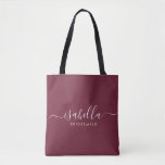 Bridesmaid Gift Burgundy Personalized Tote Bag<br><div class="desc">This Bridesmaid accessory bag features a handwritten white script typography with swashes on a burgundy background. Present your bridesmaids with a tote bag for small items traditionally presented at the rehearsal dinner,  for use in the early morning before the wedding.</div>