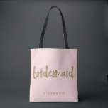 Bridesmaid Gold Glitter Blush PInk Tote Bag<br><div class="desc">This Bridesmaid tote bag is perfect for busy bridesmaids to tote around all their belongings at the bridal shower or the main event. This blush pink tote bag features faux gold glitter style lettering on the front. Personalize these totes with your wedding party member's name on the front and the...</div>