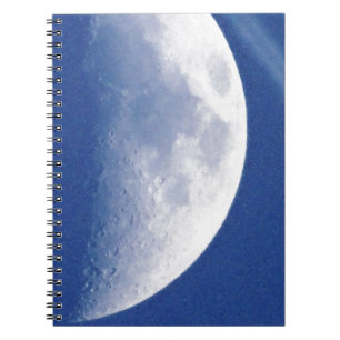 Bright half moon in blue sky notebook