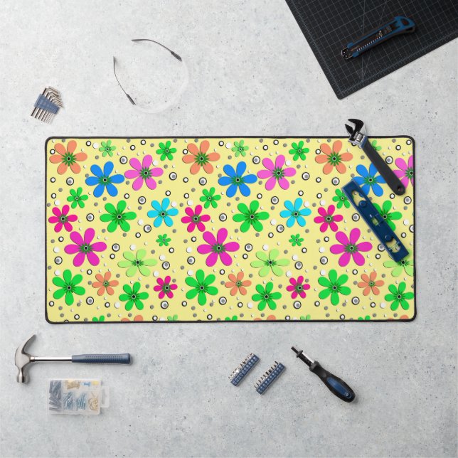 Bright multi-coloured chamomile flowers on a yello desk mat (Workstation)