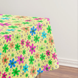 Bright multi-coloured chamomile flowers on a yello tablecloth