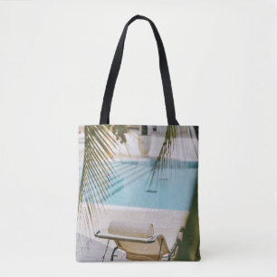 Brown and black armchair beside swimming pool in t tote bag