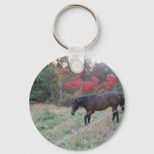 Brown horse in the red autumn trees keychain