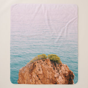 Brown rock mountain on body of water sherpa blanket